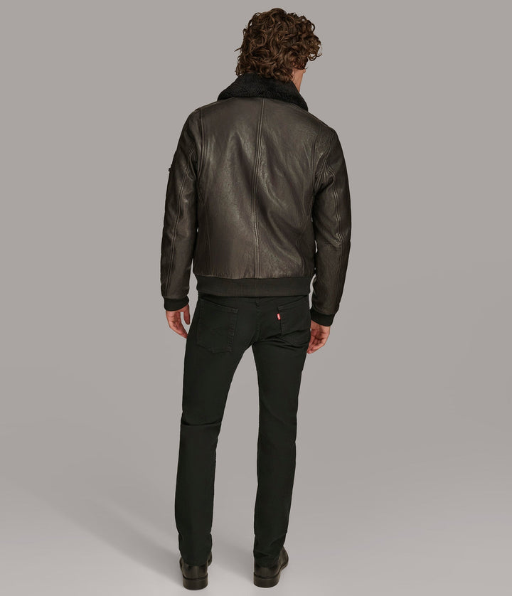 Backside view of a man wearing Black Ace Bomber Jacket with a fur lining, zipper pockets, and a rib knit collar and closed zipper 