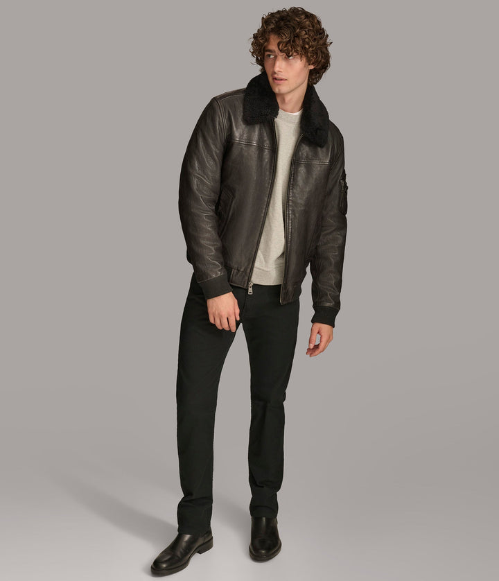 Frontside view of a man wearing Black Ace Bomber Jacket with a fur lining, zipper pockets, and a rib knit collar and Open zipper 