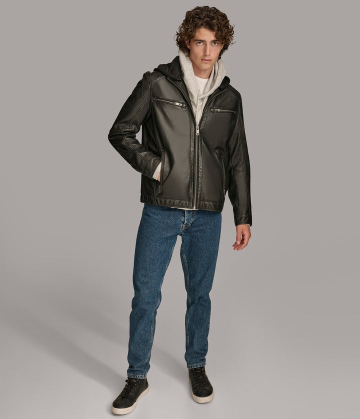 Complete frontside view of a man wearing a Nico Hooded Racer jacket with a standing collar, zipper pockets, and a detachable fleece hood, paired with blue jeans and closed zipper.