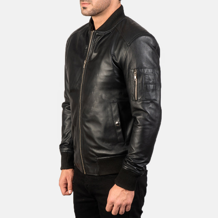 Complete  Side view of a male model wearing a Black Bomia Ma-1 Leather Bomber Jacket with a standing collar, zipper closure, and rib knit cuffs, paired with a white shirt.