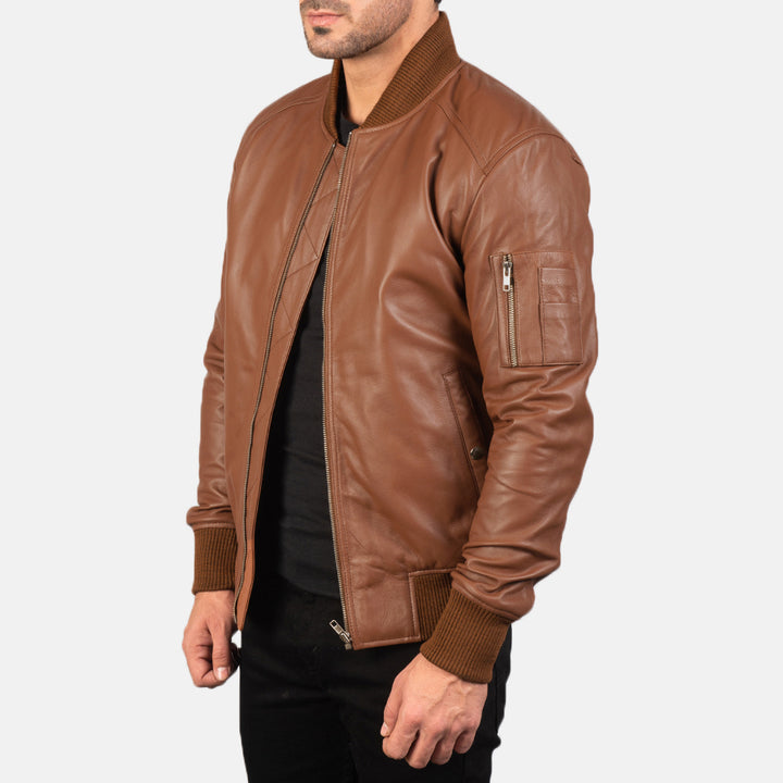 Side view of a male model wearing a Brown Bomia Ma-1 Leather Bomber Jacket with a standing collar, zipper closure, and rib knit cuffs, paired with a black t-shirt and black pants.